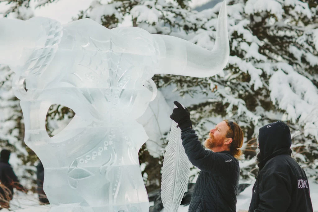Banff SnowDays Festival 2025: Exclusive Ice Magic Tickets 10 Two ice sculptors carefully assembling a detailed ice carving of a stylized bull’s head
