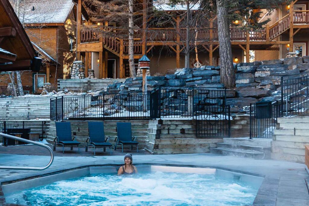 A guest relaxes in the steaming outdoor hot tub at Buffalo Mountain Lodge
