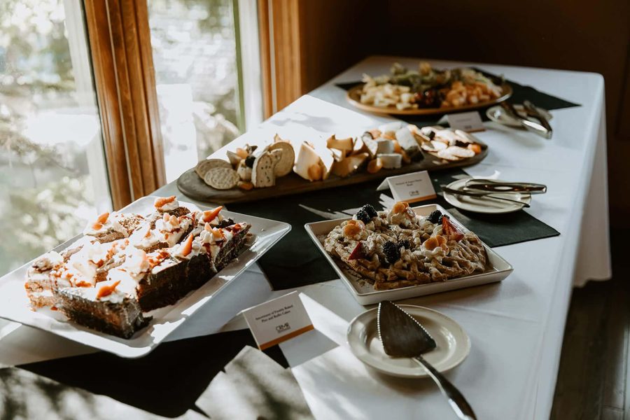 A wedding buffet table with desserts, fruit-topped pastries, and assorted cheese platters